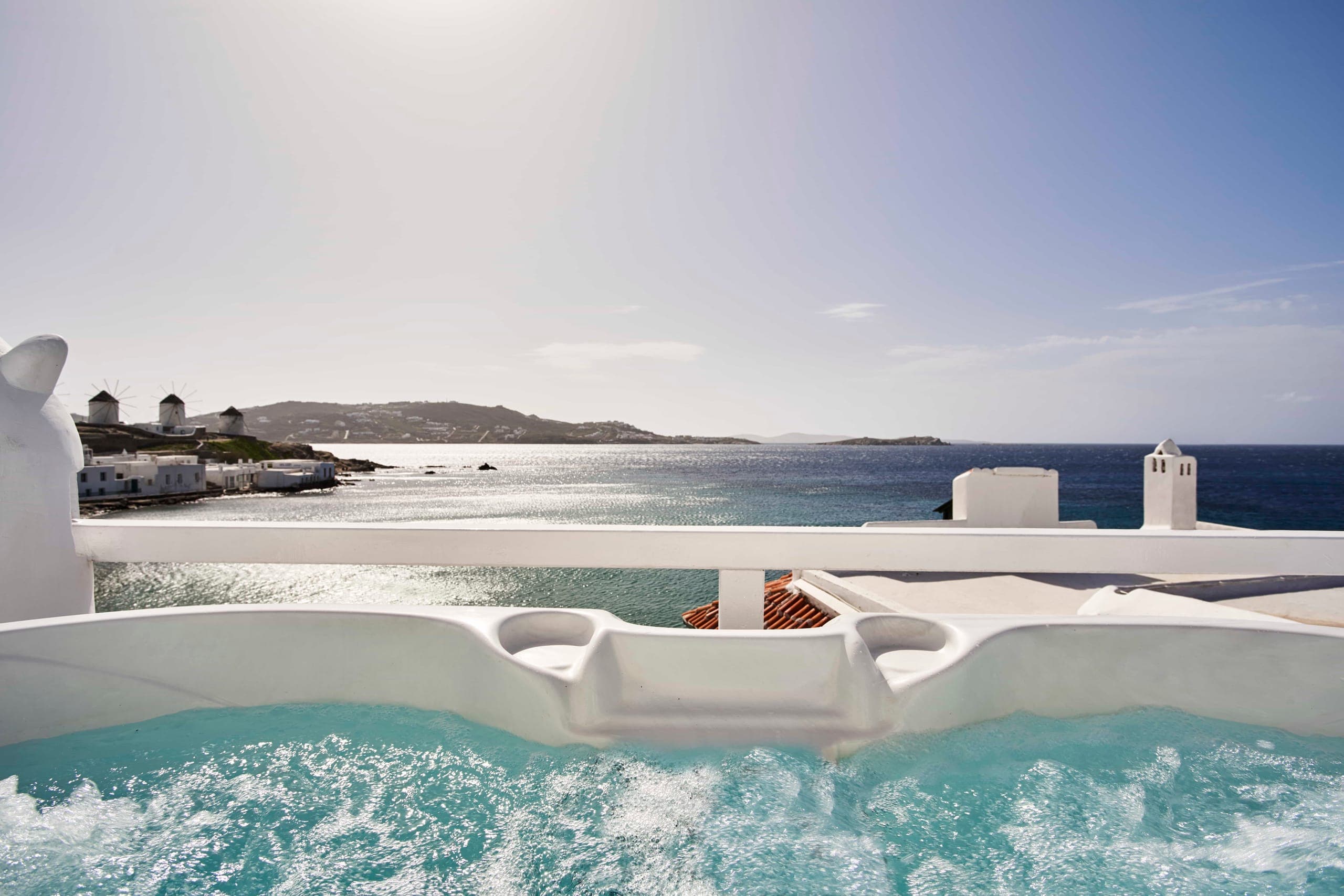 Outdoor hot tub on a private terrace overlooking the sea and the Mykonos windmills
